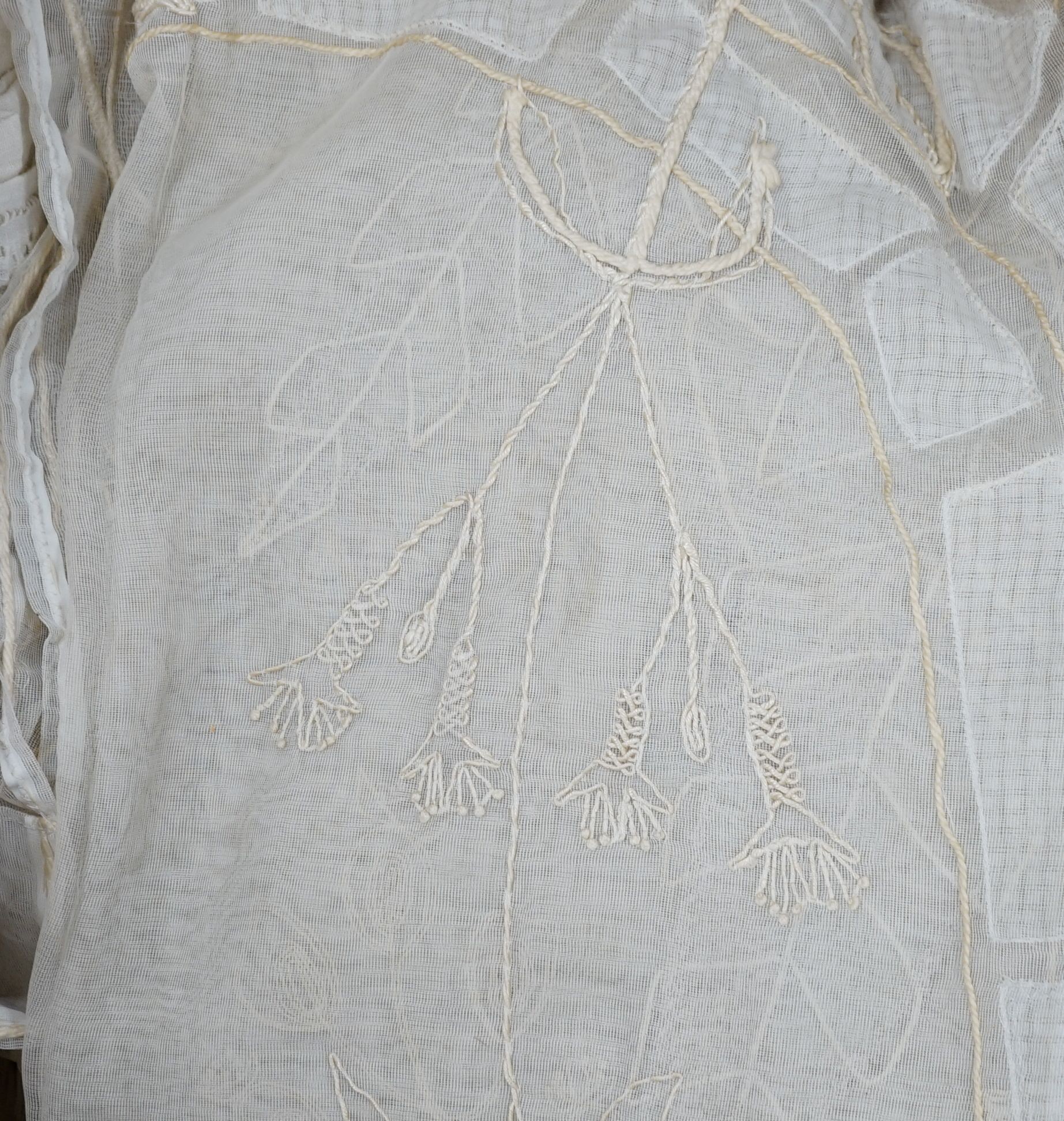 A box of mixed linen and 1950's hand embroidered cream curtain